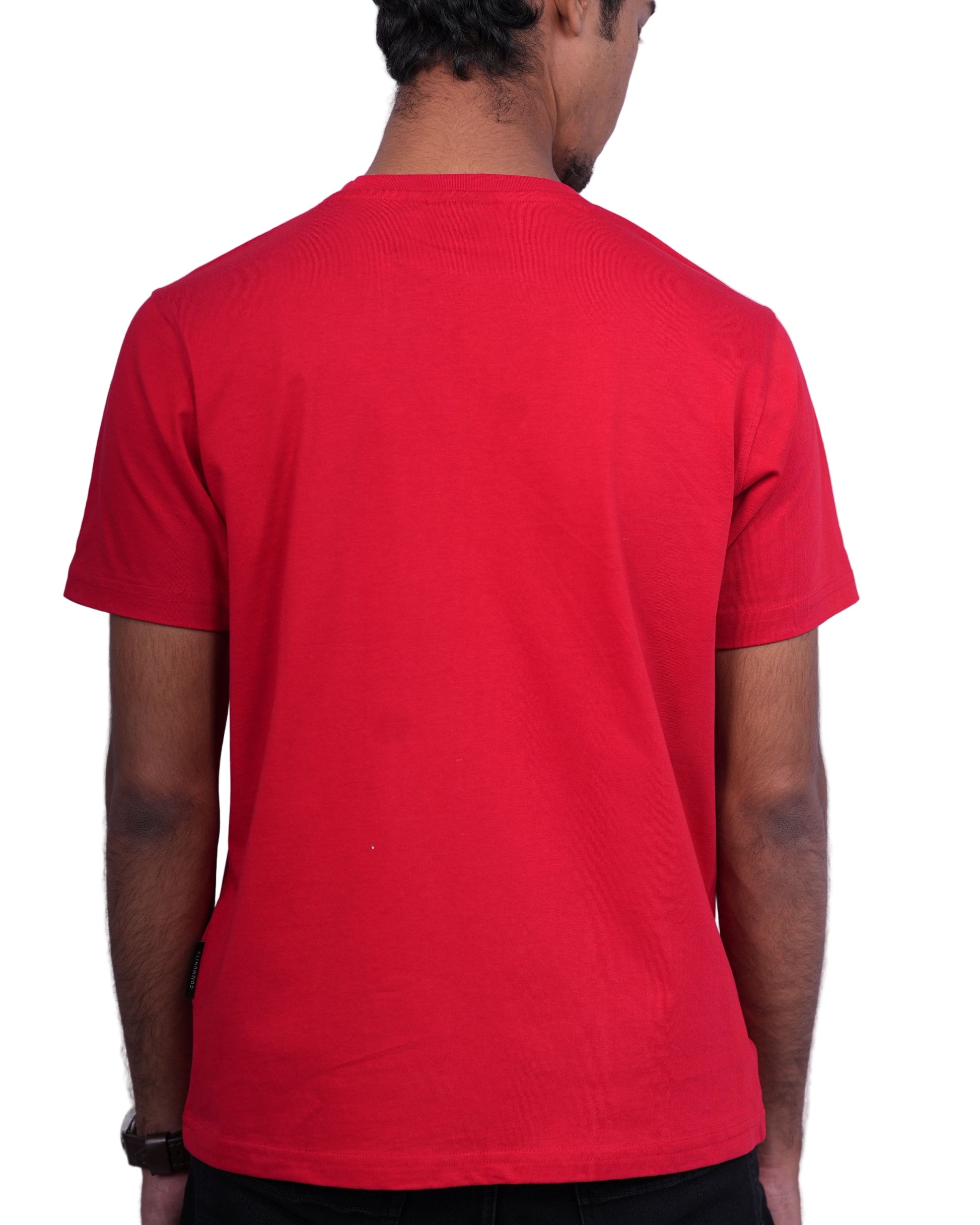 Person wearing a red shirt and black shorts on a white background